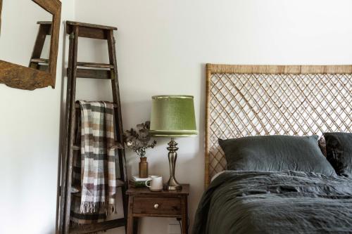 a bedroom with a bed and a green lamp at Hey Little Joe - Cosy Retreat with Mountain Views in Warburton