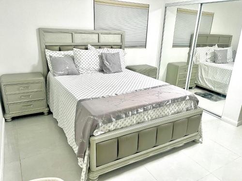 a bedroom with a large bed and a mirror at New Air VACATION FUN in Pompano Beach