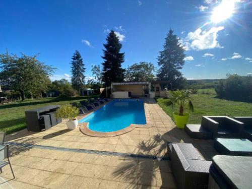 une piscine dans une cour avec des chaises et du soleil dans l'établissement Maison avec piscine, sauna, spa, à Cepoy