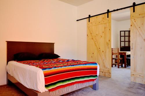 1 dormitorio con 1 cama y puerta de madera en Superbe appartement avec chambre, piscine et parking privé, en El Pescadero