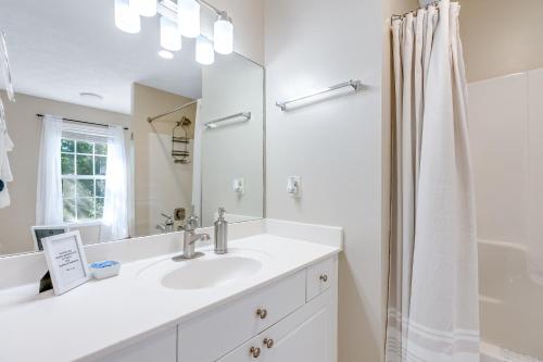 a white bathroom with a sink and a mirror at Tranquil Townhome in Auburn