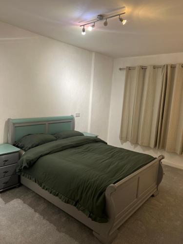 a bedroom with a bed with a green comforter at 369 apartment 9 in Birmingham