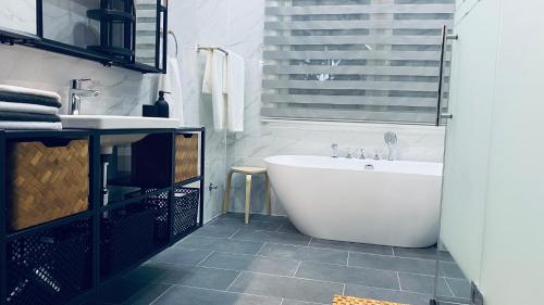 a bathroom with a white tub and a sink at Stunning 3-Bed House in Tema-Ahenfie Villa in Kwedonu