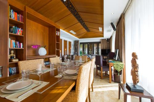 une salle à manger avec une longue table et des chaises dans l'établissement Dasiri Lakefront Villa, à Hua Hin