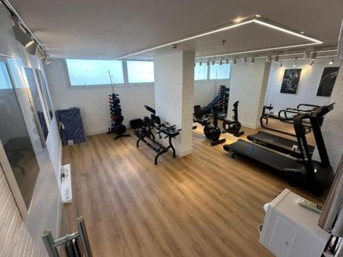 a gym with treadmills and exercise bikes in a room at Quarto 501 do Design Hotel Linhares in Linhares