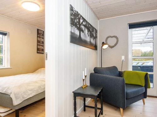 una camera con un letto e una sedia blu di Holiday home Grenaa LI a Grenå