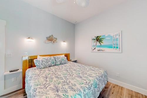 a bedroom with a bed and a picture on the wall at Salty Waves 1 in Flagler Beach