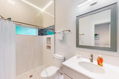 bagno con lavandino, servizi igienici e specchio di Salty Waves 1 a Flagler Beach