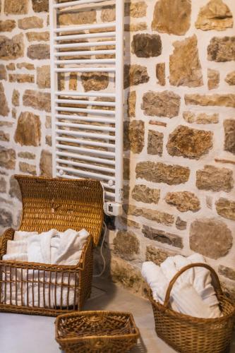 a room with wicker baskets and a stone wall at Villa Porta Qeparo in Qeparo