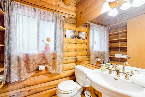 ein Blockhausbad mit einem WC und einem Waschbecken in der Unterkunft Rocky's Log Cabin in Sultan
