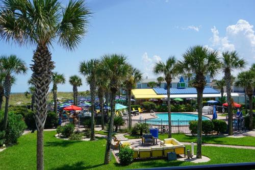 海王星海灘的住宿－Seahorse Oceanfront Inn，享有带游泳池和棕榈树的度假村的景致