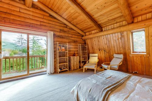 a bedroom with a bed and a large window at Rocky's Log Cabin & Retreat in Sultan