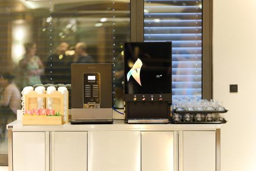 a counter with a coffee maker and a laptop on it at Hotel Vema in Visoko