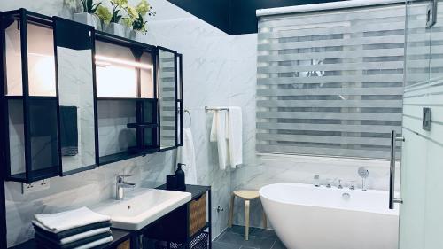 ein weißes Badezimmer mit einer Badewanne und einem Waschbecken in der Unterkunft Stunning 3-Bed House in Tema-Ahenfie Villa in Kwedonu