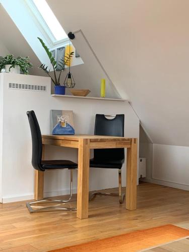 a desk with a chair and a table under a staircase at Dachwohnung Nähe Clemenshospital in Münster