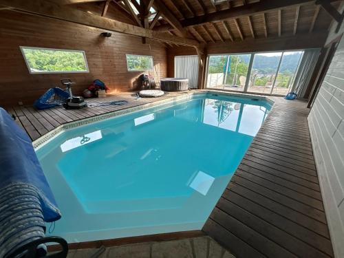 a large swimming pool in a house at Cosy Chalet au cœur du Sidobre avec Piscine et Spa in Vabre