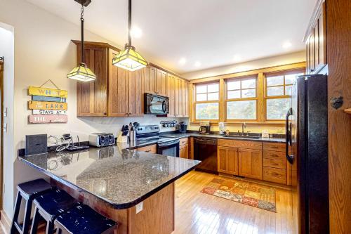 a kitchen with wooden cabinets and a black refrigerator at Relaxation Ridge in Oakland