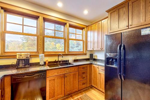 a kitchen with wooden cabinets and a stainless steel refrigerator at Relaxation Ridge in Oakland