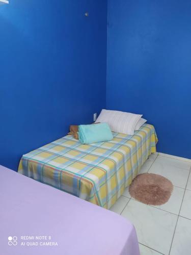 Bett in einem Zimmer mit blauer Wand in der Unterkunft Casa da Serra Centro in Guaramiranga