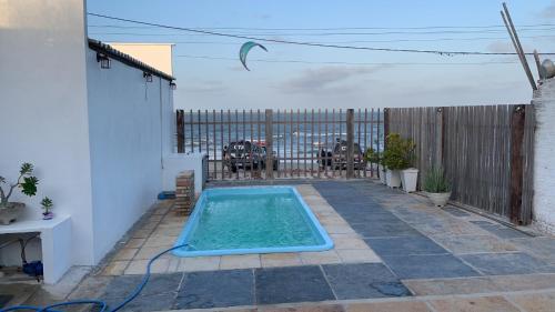 a small swimming pool in a backyard with a fence at Pousada Lua Branca in Tutóia