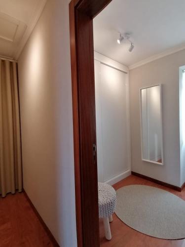 a room with a door with a stool and a mirror at Vivenda Oliveira - Alojamento Local in Lamego
