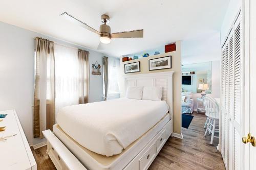 biała sypialnia z łóżkiem i salonem w obiekcie Gulf Highland, Unit A w mieście Panama City Beach