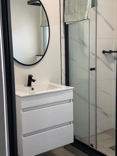 a bathroom with a sink and a mirror at Cosy Munyaka Waterfall Apartment in Midrand