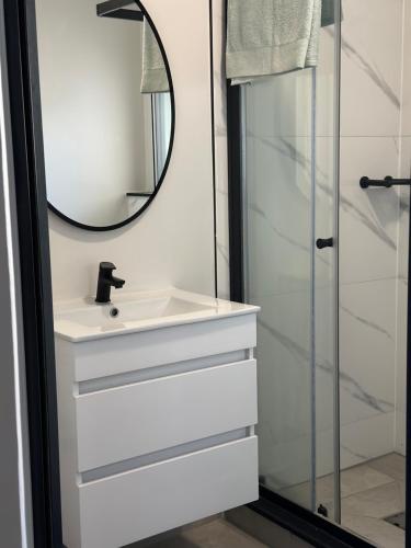a bathroom with a sink and a mirror at Cosy Waterfall Midrand Apartment in Midrand
