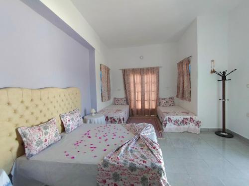 1 dormitorio con 1 cama y 1 cruz en la pared en Henchir ejdoud en Kairouan