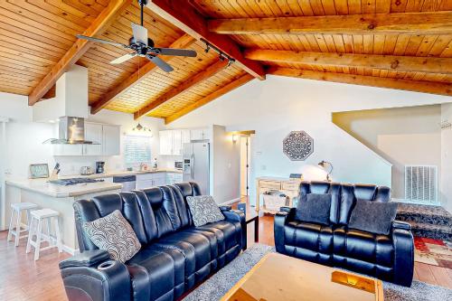 a living room with a leather couch and a kitchen at Red Umbrella Hideaway in Groveland