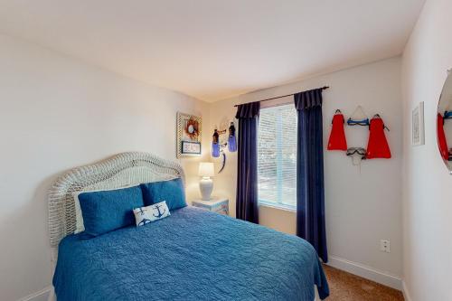 Un dormitorio con una cama azul y una ventana en Angola By The Bay --- 22740 Holly Way West, en Long Neck