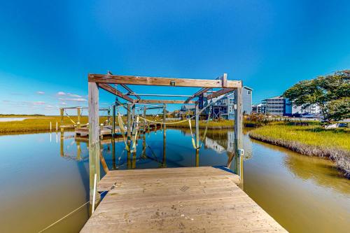 a wooden dock on a body of water at Sand Dollar Hideaway in North Topsail Beach
