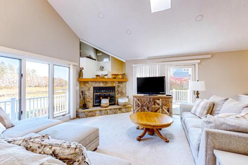 a living room with a couch and a tv at Barefoot Bliss in Kennebunk