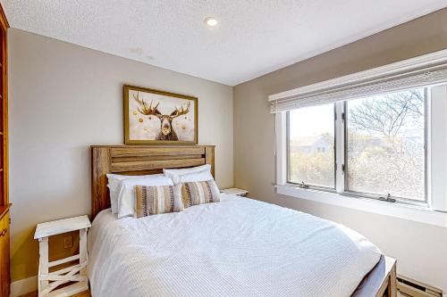 a bedroom with a white bed and a window at Barefoot Bliss in Kennebunk
