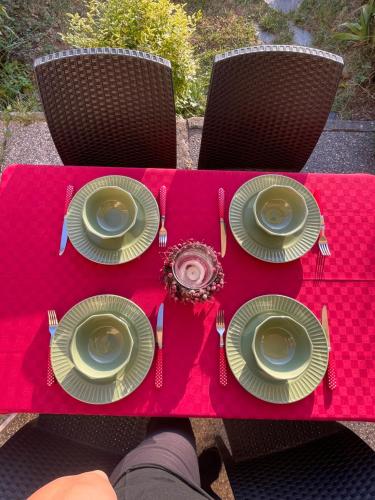 une table avec des assiettes et des ustensiles sur une table rouge dans l'établissement LA CASETTA del MIRTILLO ROSSO, à Santo Stefano dʼAveto