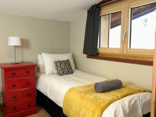 um quarto com uma cama, uma cómoda e uma janela em Penthouse Apartment, 2 Bedroom, 2 Bathroom em Chamonix-Mont-Blanc