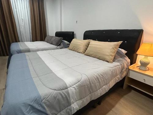 um quarto com uma cama e uma mesa com um candeeiro em Armadale Residence-Gala City em Kuching