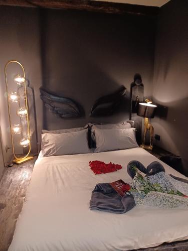 a bedroom with a bed with white sheets and flowers on it at DANTES in Pieve di Teco