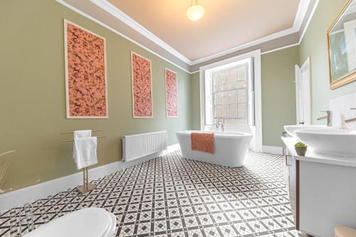 a bathroom with a tub and two sinks at 8 Corkickle in Whitehaven
