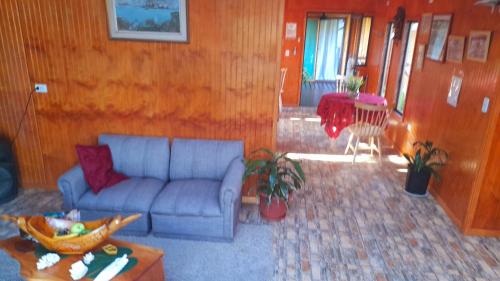 uma sala de estar com um sofá e uma mesa em Hostal Makohe Rapa Nui em Hanga Roa