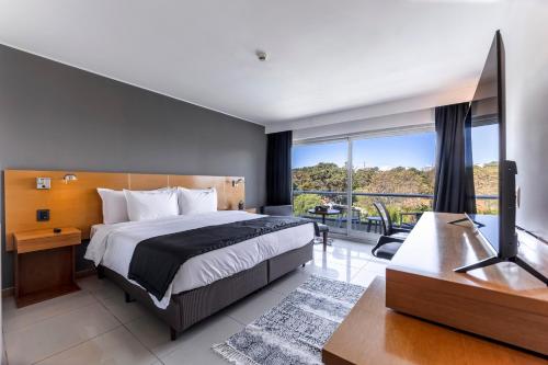 a bedroom with a large bed and a balcony at Park Hotel in Punta del Este
