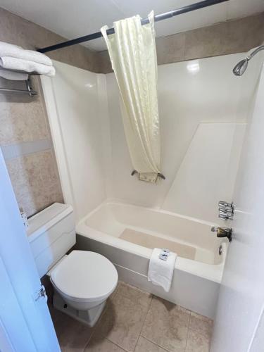 a white bathroom with a toilet and a tub and a toilet at Hotel 81 El Reno in El Reno