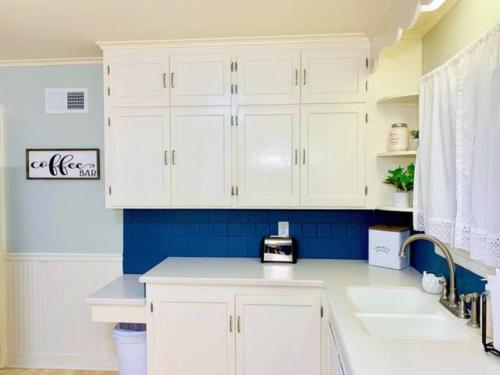 a kitchen with white cabinets and a blue wall at Peoria Speedway Rocky Glen Bradley Park 4bdrm Home in West Peoria