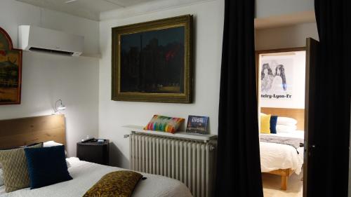 a bedroom with two beds and a picture on the wall at Hostelry Music Repetition in Écully