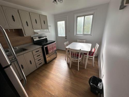 a kitchen with a white table and a table and chairs at Appartement une chambre - 576 in Montreal