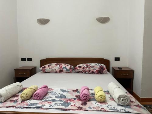 a bed with four blankets and pillows on it at ~Villa Gloria~ in Durrës