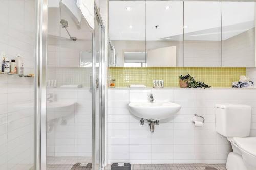 uma casa de banho branca com um lavatório e um WC em Waterfront Resort-Style Living at Glenelg Beach em Glenelg