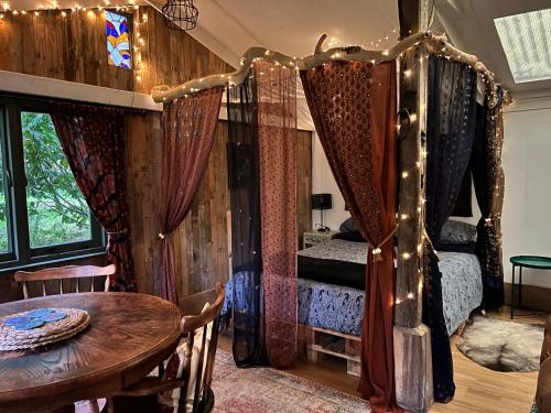 a bedroom with a bed and a table and a dining room at Off the Beaten Shack in North Hill