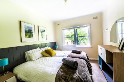 1 dormitorio con 1 cama y 2 ventanas en Welcome on Wellington, en Warburton