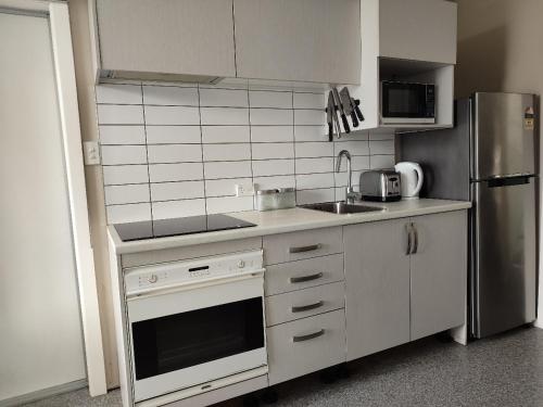 a small kitchen with a sink and a refrigerator at Napier Art House Backpackers in Napier